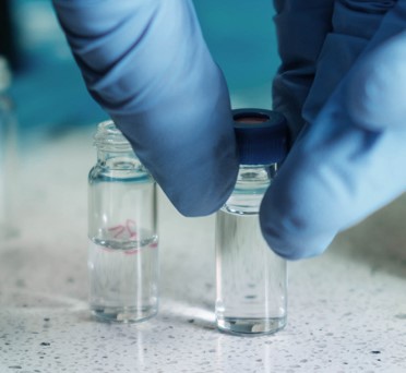 Photo of hands hold test tubes containing liquid